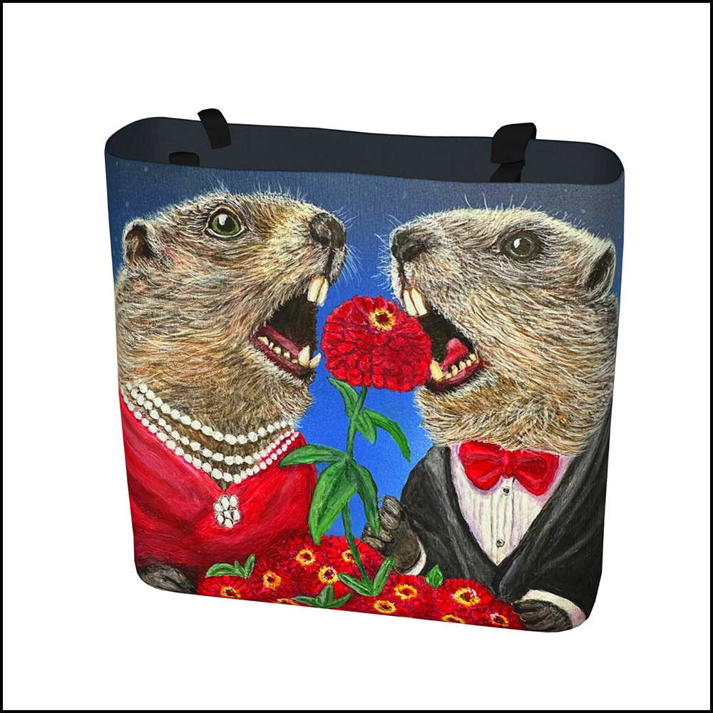 A fabric tote bag featuring a satirical painting of sophisticated groundhogs dressed in formal attire eating prized zinnias at an outdoor café table.