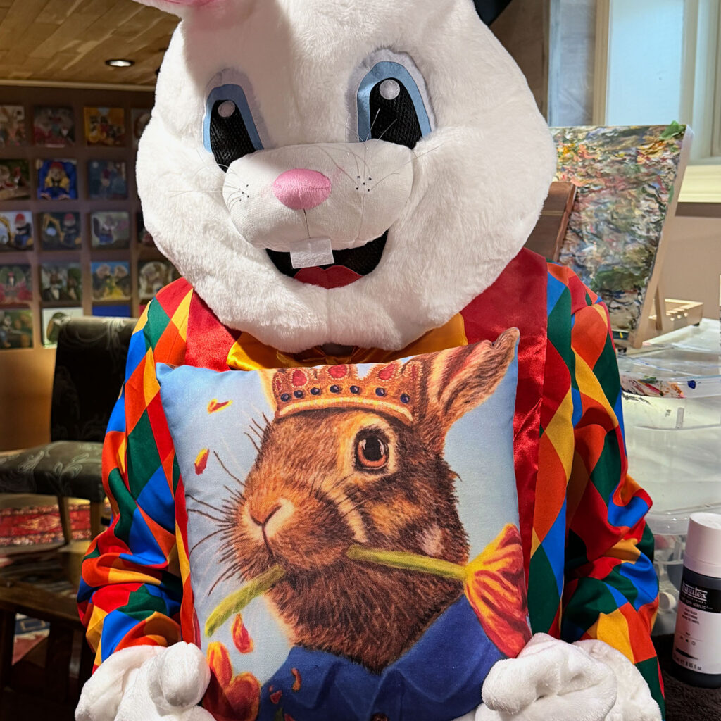 The Bloomin Fool holding the Rabbit Eating Tulips 1.0 pillow to check color accuracy and fabric alignment.